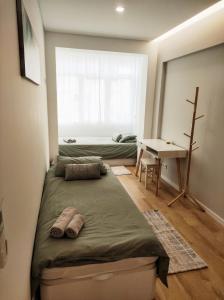 埃斯托利尔Elite House Estoril的一间卧室配有一张床、一张书桌和一个窗户。