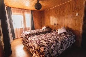 维库尼亚Hostel Antawara的一间卧室设有两张床和窗户。