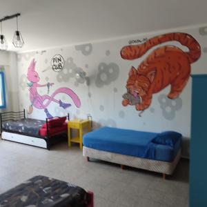 门多萨rafa's house的一间设有两张床的客房,墙上挂着老虎壁画