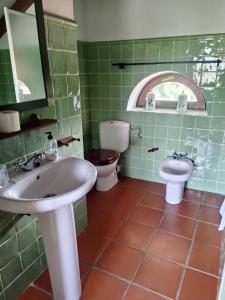 AbiadaCasavieja Rural的绿色瓷砖浴室设有水槽和卫生间