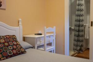 赫雷斯-德拉弗龙特拉Sanvi Xerez Centro的卧室配有1张床、1张桌子和1把椅子