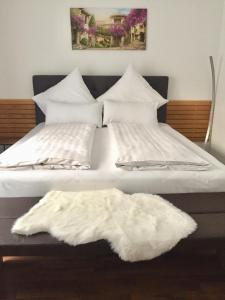 腓特烈港Ferienwohnung am Bodensee- zentrale Lage, free parking and wifi, 109 m2, privater Garten, 7 Gäste, 2x Kingsize Boxspringbett, familienfreundlich的一张带白色枕头的床和白色地毯