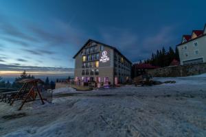 米克山Montis Hotel & Spa的雪上标有标志的建筑