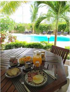瓦塔穆Luxury Simba House in Watamu [ ☆☆☆☆☆ ]的餐桌旁的桌边,桌边有食物和饮料