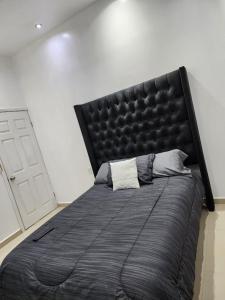 CuauhtémocDepartamentos L的卧室内的一张大床和黑色床头板