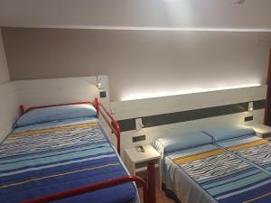 Alcorisa城堡餐厅及酒店的一间卧室配有两张床,还有一个床头柜和床架