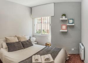 塞维利亚Apartamento New Folch Sevilla A的一间卧室配有一张大床和毛巾