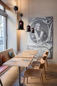 格尔利茨格尔利茨艾默里奇酒店的用餐室配有木桌和墙上的绘画作品