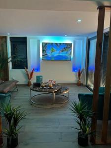 洛翁普拉日ESCAPE ZEN Oasis tropicale & Spa privatif的客厅配有桌子和蓝光灯