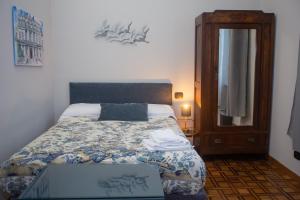热那亚Il Giardino della Tartaruga的一间卧室配有一张带桌子和镜子的床