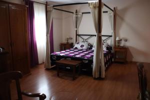阿尔卡扎德三涓文塔埃尔莫林诺酒店的一间卧室设有一张天蓬床和木地板。