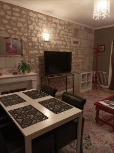 希农La Boussole - Maison meublée 3 chambres 6 pers.的客厅配有桌子和平面电视。