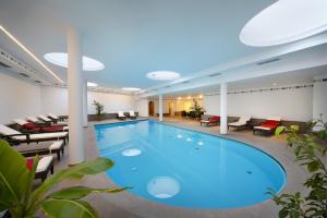 阿皮亚诺苏拉斯特拉达乌特林酒店的酒店的大型游泳池配有桌椅