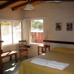 蒂尔卡拉Hotel Punta Corral的卧室配有床、椅子和窗户。