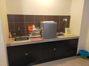 马六甲Bayou lagoon Muslim Apartment的厨房柜台设有水槽和微波炉