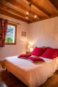 塔南日GITE BALNEO LES AMARYLLIS的一间卧室配有一张带红色枕头的大床
