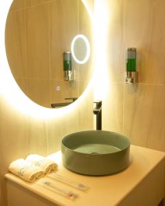 TubigonSeeya Hotel的浴室水槽和上面的圆镜子