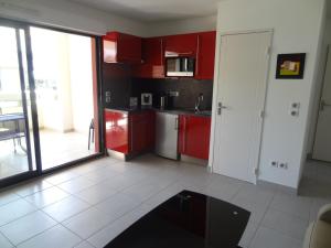 塞特港Appartement Sète, 2 pièces, 4 personnes - FR-1-472-113的厨房配有红色橱柜和白色瓷砖地板。