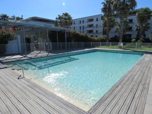 塞特港Appartement Sète, 2 pièces, 4 personnes - FR-1-472-113的一个带木制甲板的大型游泳池