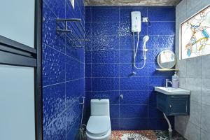 小笨珍OYO Home 90332 Jentayu Homestay Pontian的蓝色瓷砖浴室设有卫生间和淋浴。
