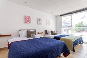 墨西哥城Condesa, Depto 2 recamaras.的一间卧室设有两张床和大窗户