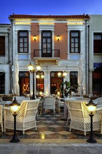 罗希姆诺Civitas Suites Hotel的大楼前设有桌椅的餐厅
