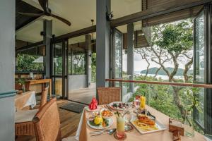 珍南海滩Ambong Rainforest Retreat的用餐室配有餐桌和食物