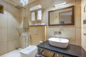 KondottiHOTEL CASON INTERNATIONAL的一间带水槽、卫生间和镜子的浴室