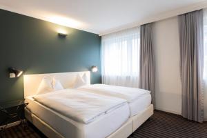 圣加仑Self Check-In Hotel David 22的卧室配有一张大白色床和窗户