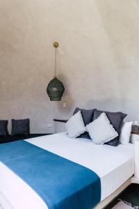 爱妮岛Panorama Beach Club & Resort的一间卧室配有一张带蓝白色枕头的大床