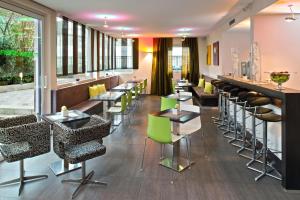 美因河畔法兰克福总站酒店的一间带桌椅的餐厅和一间酒吧