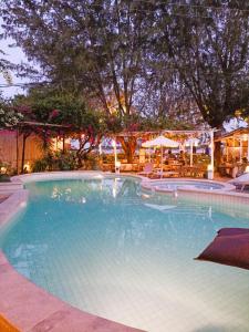 吉利特拉旺安阿尔马里克别墅度假酒店的一个带桌子和遮阳伞的大型游泳池