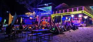 哈林海滩Phangan Mantra Inn的一群人晚上坐在街上的桌子上