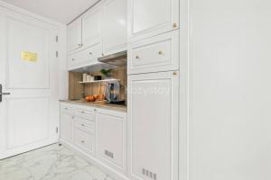 万隆Askara by Kozystay Hot Tub的白色的厨房配有白色橱柜和大理石地板。