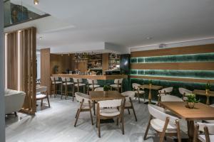 海若克利欧Dimargio Luxury Hotel & Spa的一间带桌椅的餐厅和一间酒吧