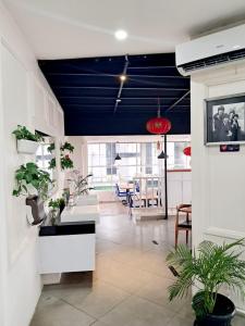 棉兰Cordela Inn Millennium Medan的客厅拥有蓝色的天花板和盆栽植物