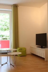 明斯特旅行公寓的客厅配有桌子和电视