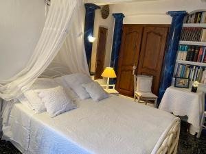 邦多勒La Florentine的一间卧室配有白色的床和蓝色窗帘