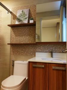 马尼拉Adria Residences - Ruby Garden - 2 Bedroom for 4 person的一间带卫生间、水槽和镜子的浴室