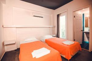 奥塔肯特Muskebi Apart Otel的配有橙色床单的客房内的两张床