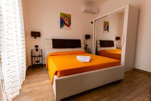 锡拉库扎Appartamenti Vittoria的一间卧室设有两张床和大镜子