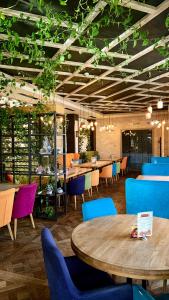 伊万诺-弗兰科夫斯克Cruce de Gustos的一间设有桌椅的餐厅,种植了植物