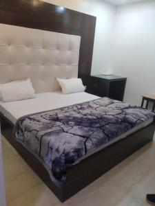 阿格拉Hotel Uday Raj By WB Inn的一间卧室配有一张大床和大床头板