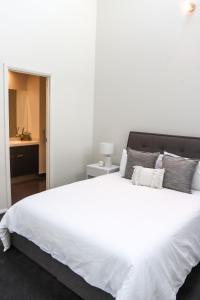 本迪戈Bendigo Townhouse - Walk to the CBD的卧室配有一张带白色床单和枕头的大床。