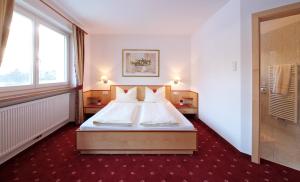 卢塔戈Appartement Hotel Erlhof Deluxe的酒店客房设有床和窗户。