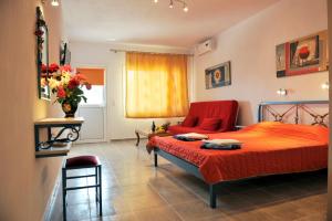 梅加利阿莫斯芬格罗斯村酒店的一间卧室配有红色的床和一张沙发