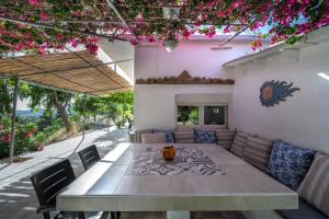 普拉基亚斯Vrisidia Cottage - Nature, Seaview & Relax的一间带桌椅和鲜花的用餐室