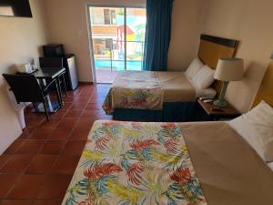 亚武科阿帕拉多帕尔马斯露西亚的酒店客房设有两张床、一张桌子和一张书桌。