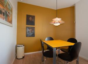 TjæreborgGuesthouse Tradsborgvej的一间设有黄色墙壁和桌椅的用餐室