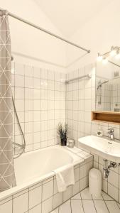 福森Ferienanlage Neuschwansteinblick Ferienwohnung 127的白色的浴室设有浴缸和水槽。